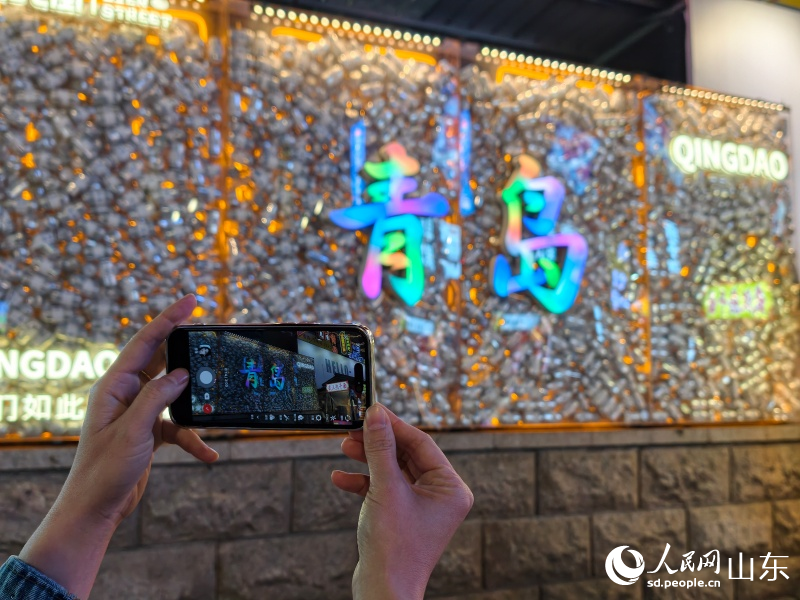 游客用手机拍摄夜市热门打卡点。人民网记者 刘颖婕摄